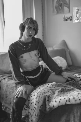 A black and white photo of Robin D'Banc sitting on the edge of her bed.