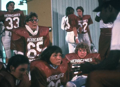 A group of women in red football uniforms in a locker room.