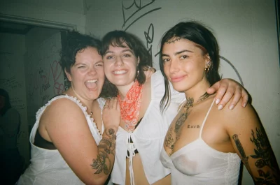 A few girls posed together in the bathroom of a bar.