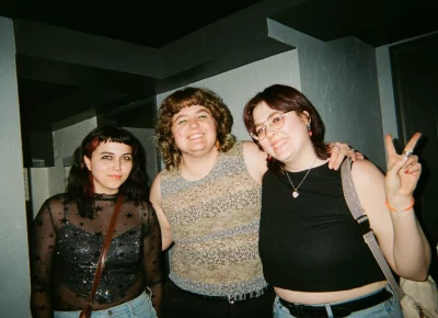 A few girls posing for a photo while in the bathroom of a bar.