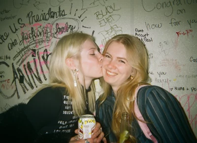 A few girls posing for a photo while in the bathroom of a bar.