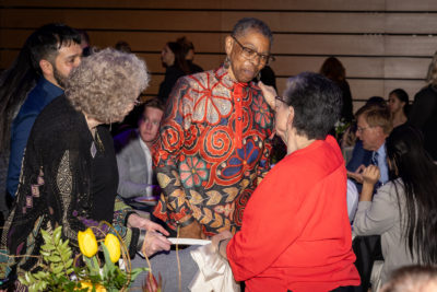 Woman holds another woman by her shoulder