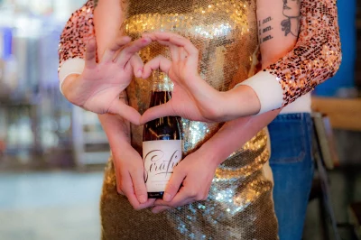 Vanderwerf and Sapula pose with a bottle of beer from their brewery.