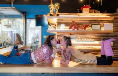 Vanderwerf and Sapula pose kissing a bottle of beer. 