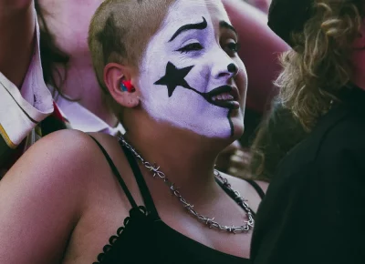A fan of The Garden wears facepaint in the crowd.