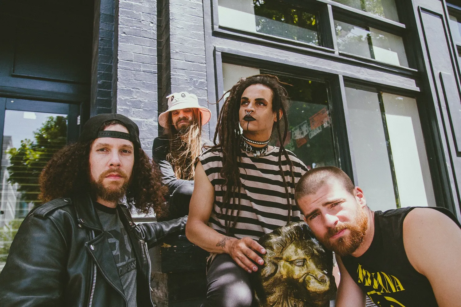 DoomCupcake band members together with a golden lion statue.