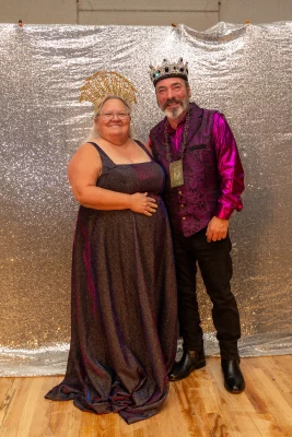 A man and woman in large crowns stand side by side. 
