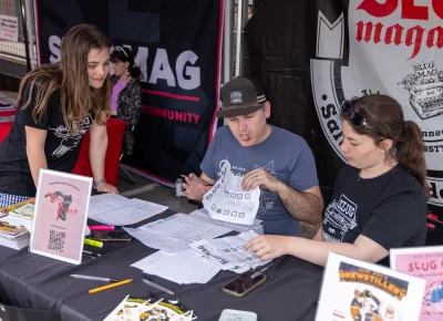 Katya, John and Erin tally the scores on the SLUG Cat manifests. Extra points were awarded for impressive displays of skill or luck at each game stop on the route. Photo: John Barkiple.