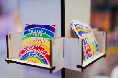 Two wooden shelves holding pride stickers.