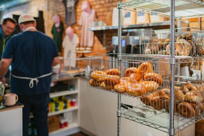 The interior of Baby's Bagels, with baskets of bagels in the kitchen.