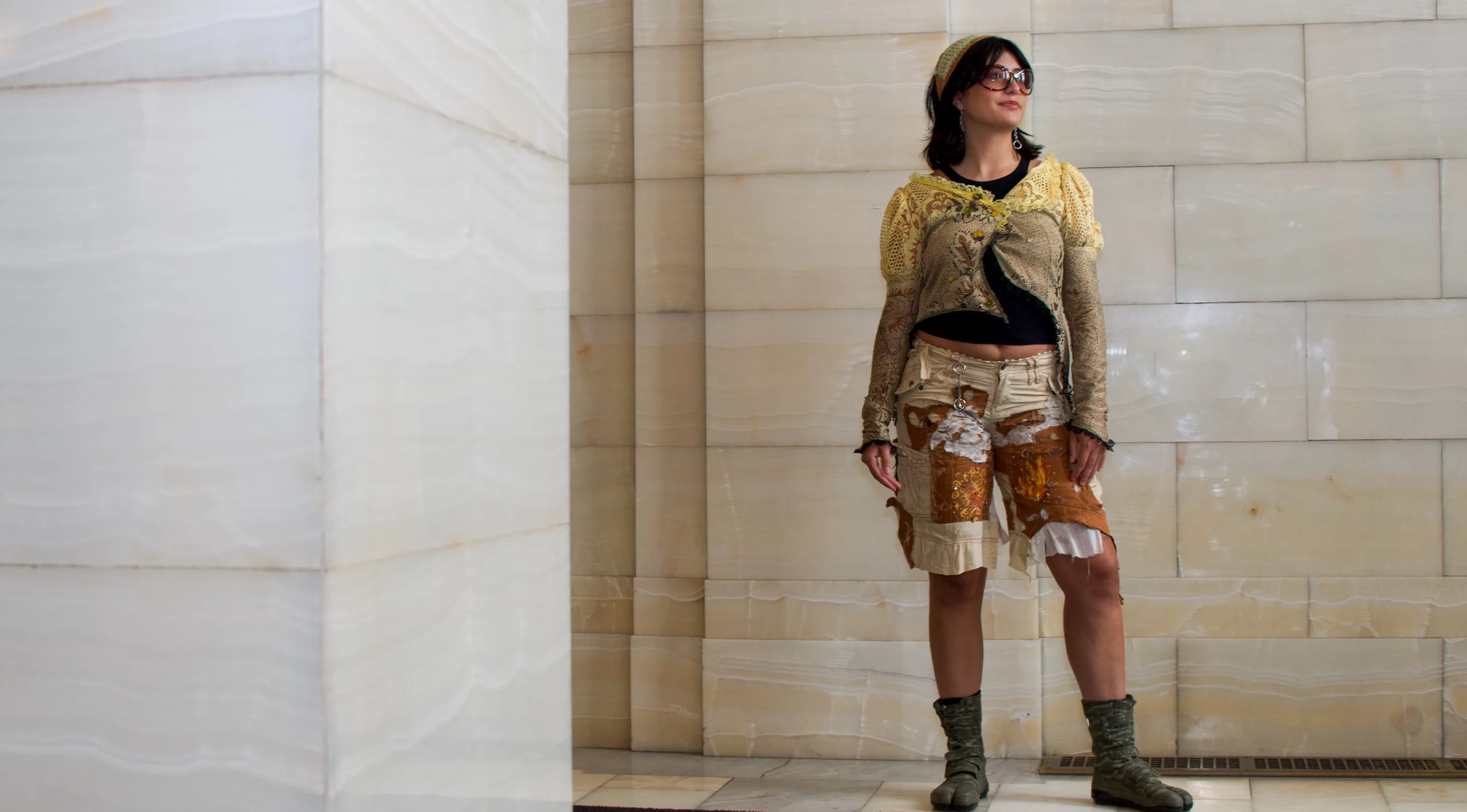 Ashley Favila poses in front of a cream marble wall.