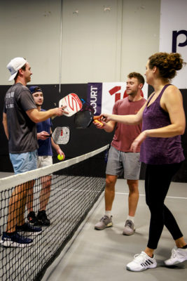 Four people put their rackets together.