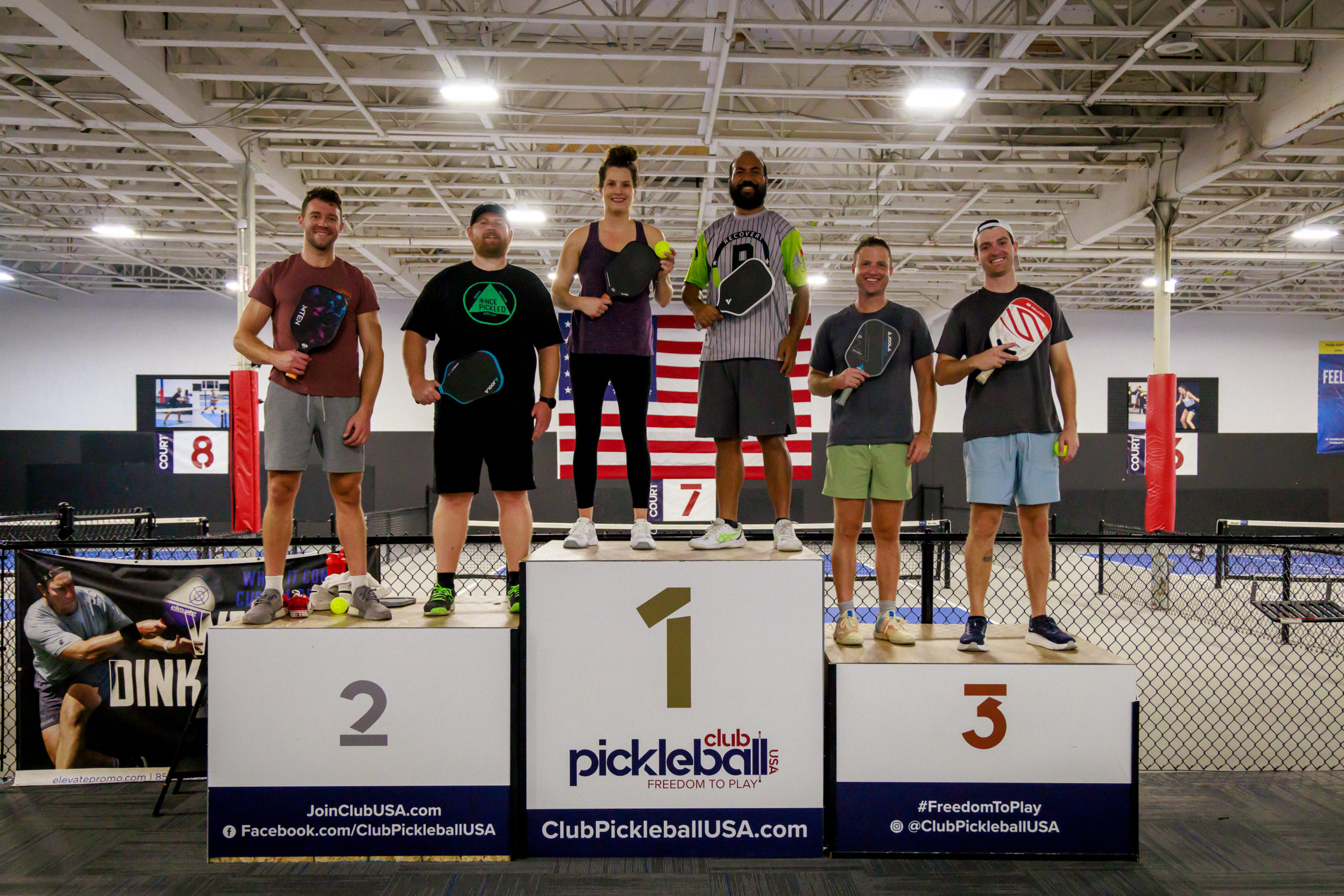 Members of OncePickled stand on award podiums.