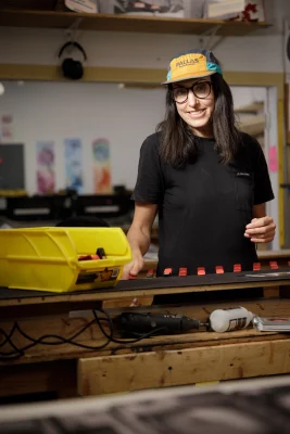 Kate Colgan stands at a work bench.