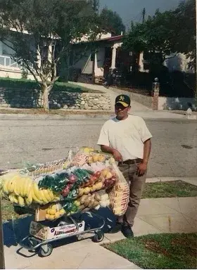 An old photo of Angel Juarez selling fruits outside.