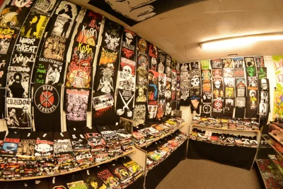 Floor to ceiling display of various rock shirts adorn the wall of Olifer's Rock Shop.