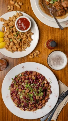 Two large plates of food sit on a wooden table.
