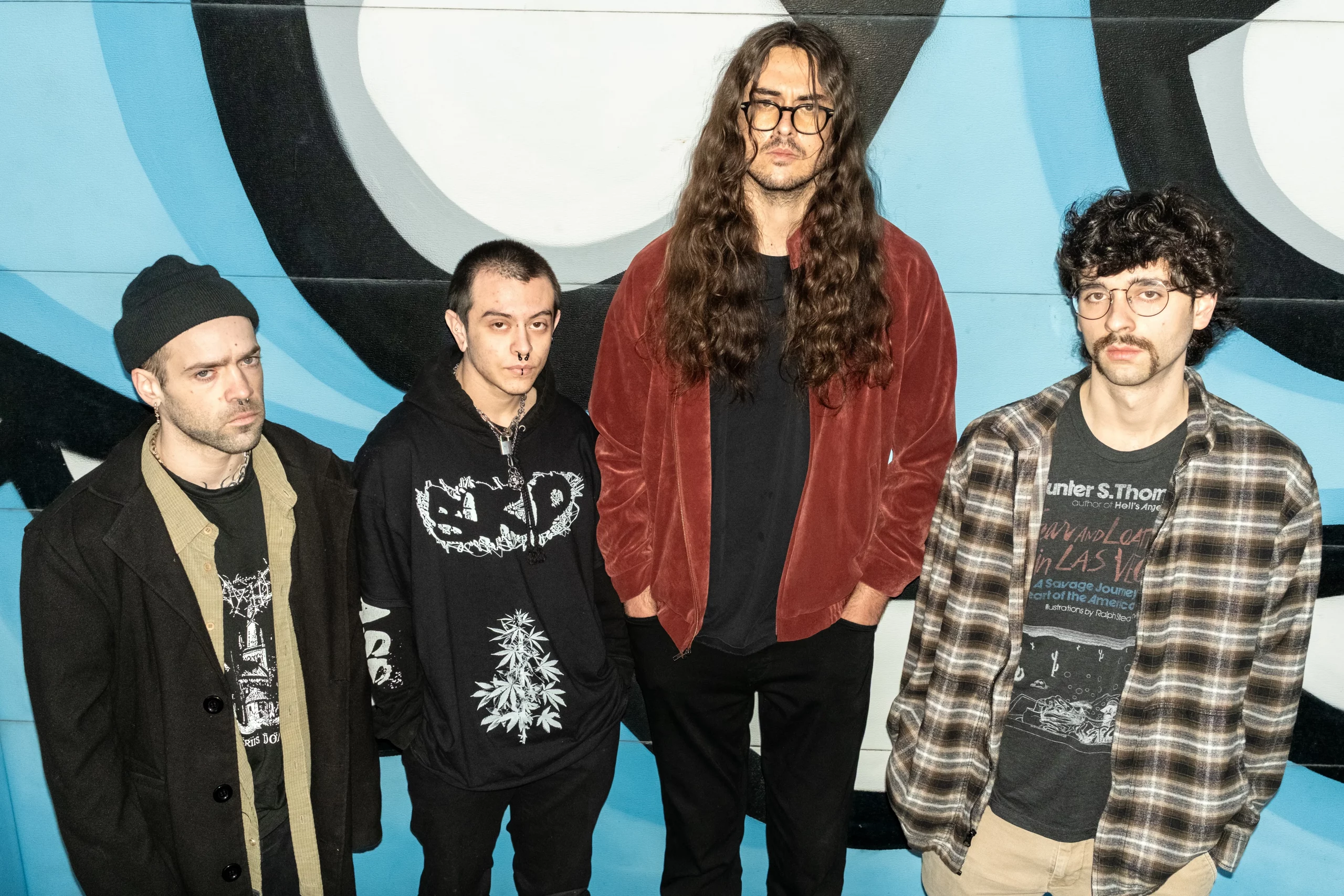 The members of Vape Plug stand in front of a wall.