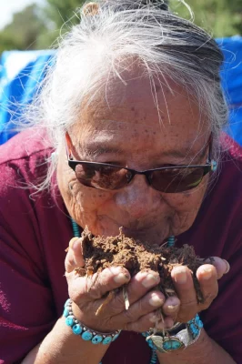 A gardener holding soil.