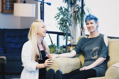 Rita Rutland sits with a patient at Restorative Health Utah.