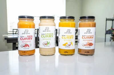 The lineup of Parami's bottled curries on a kitchen counter.