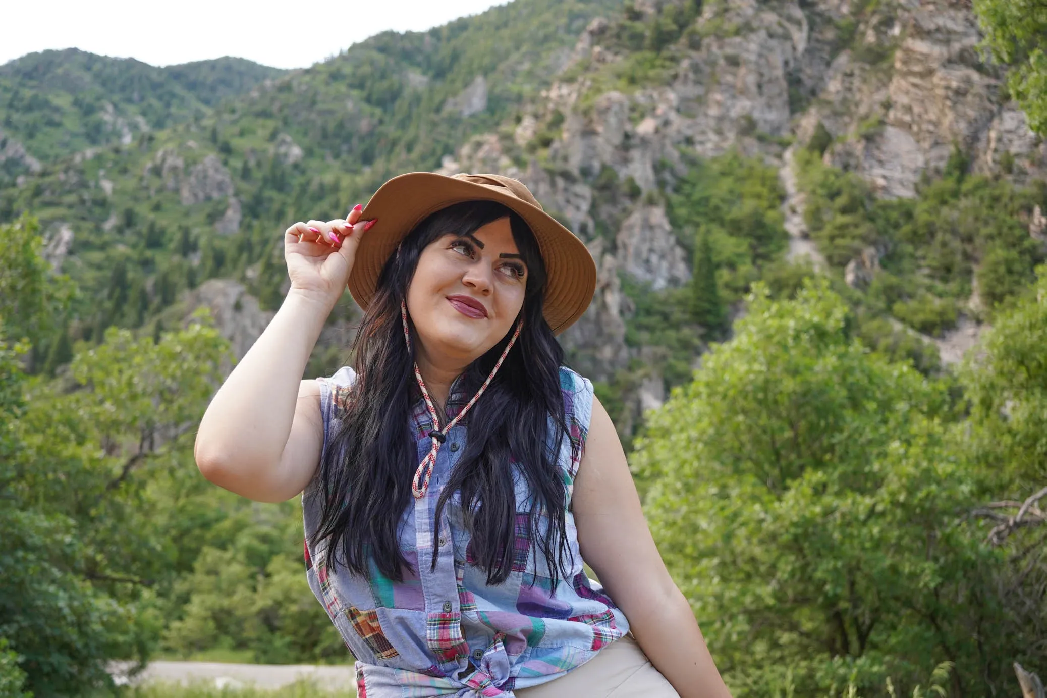 Jenn Wiggins poses in front of a forested backdrop.