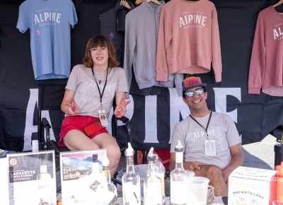 Alpine Distilling's Alyx and Aidan enjoy selling their rad merch under the tent.