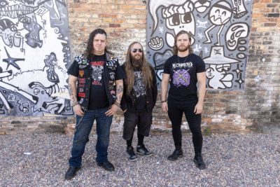 DiseNgaged members stand in front of grafitti together.