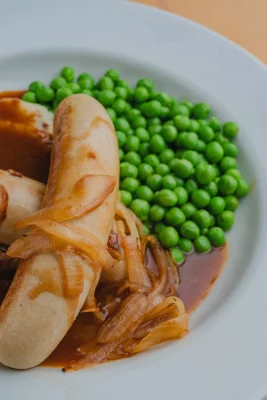 A closeup of Bangers & Mash with peas. 