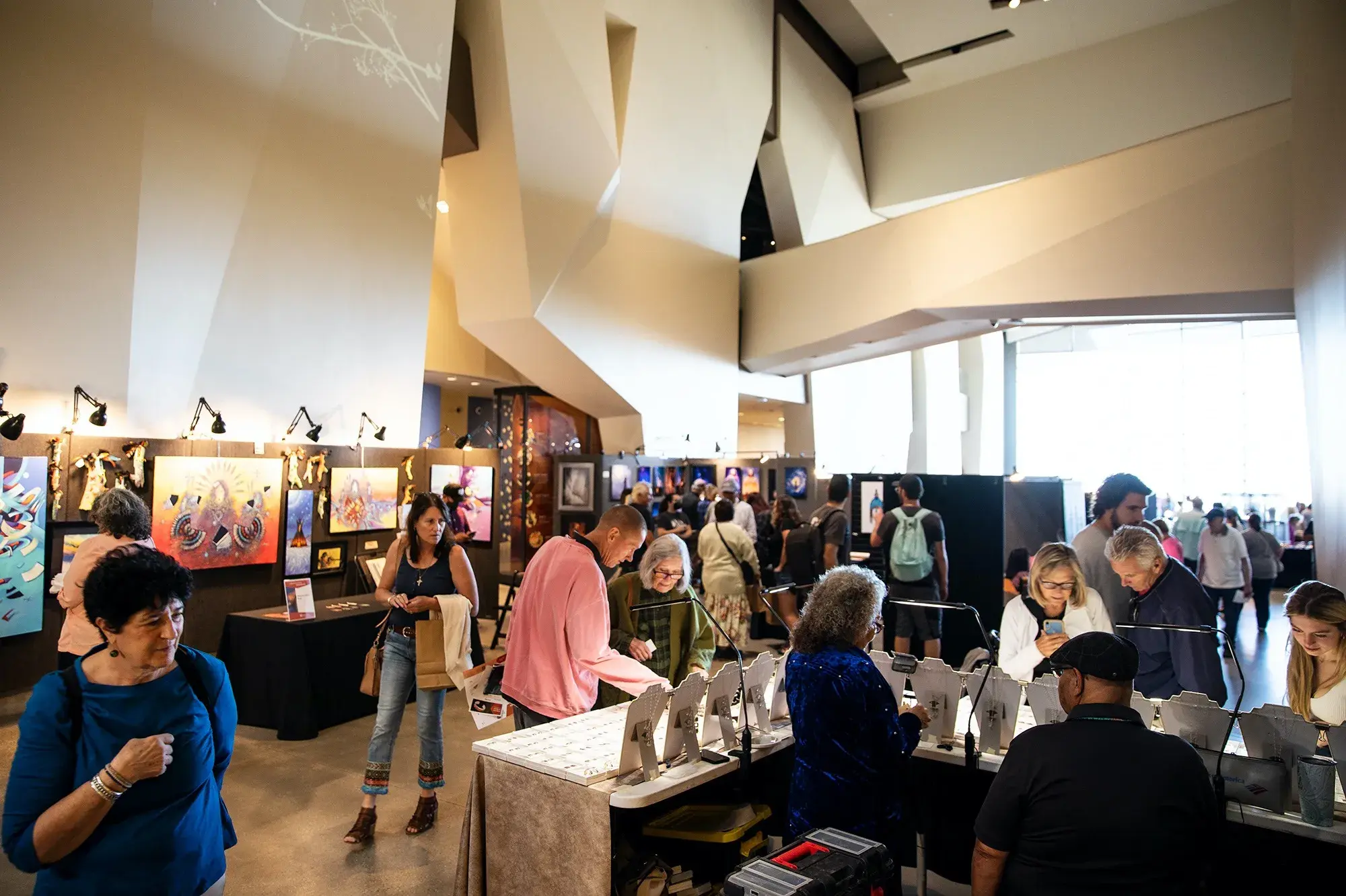 People looking at art and jewelry at the NHMU's annual Indigenous Art Market.