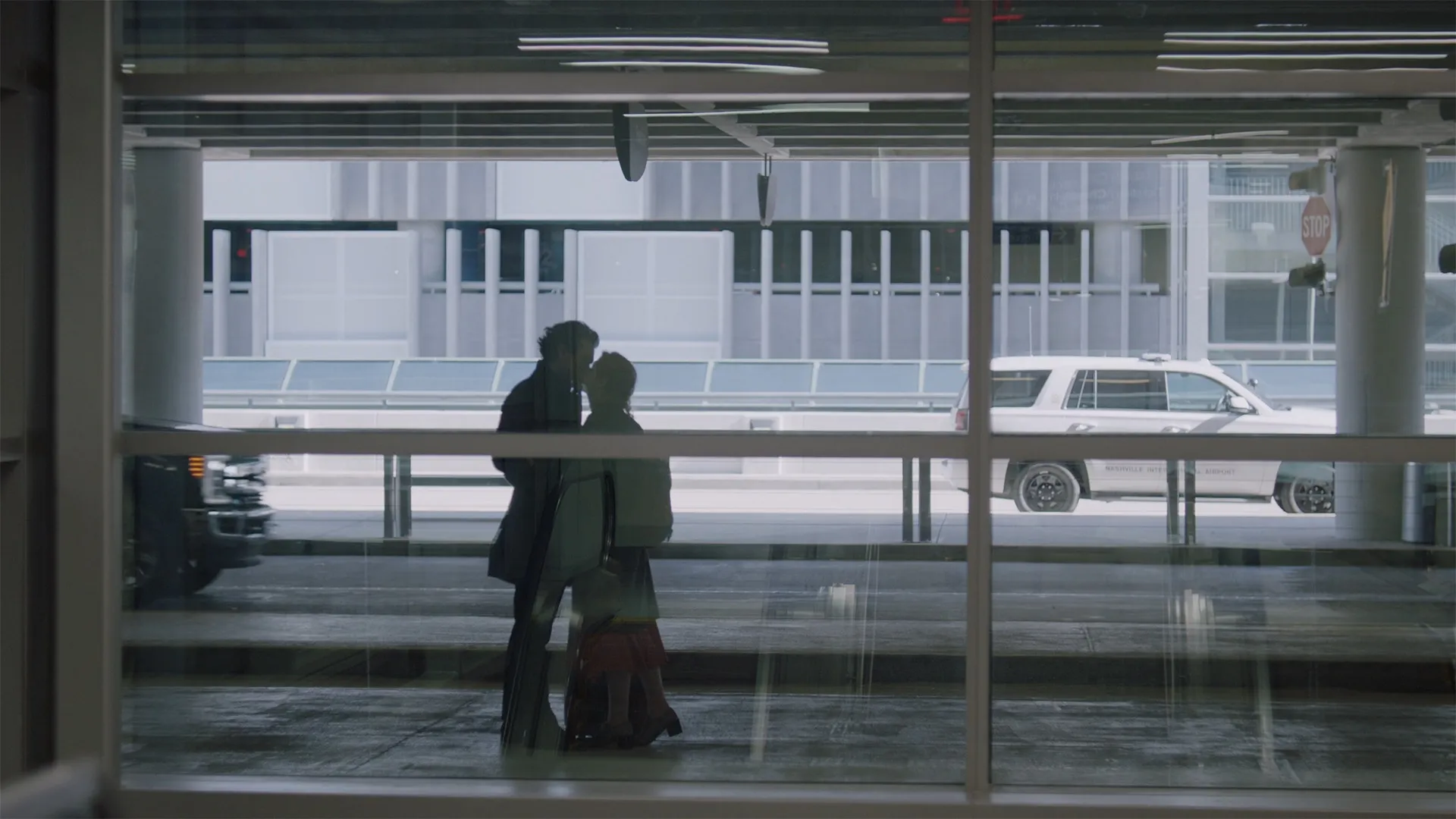 Characters Sara and Joseph kiss at the airport.