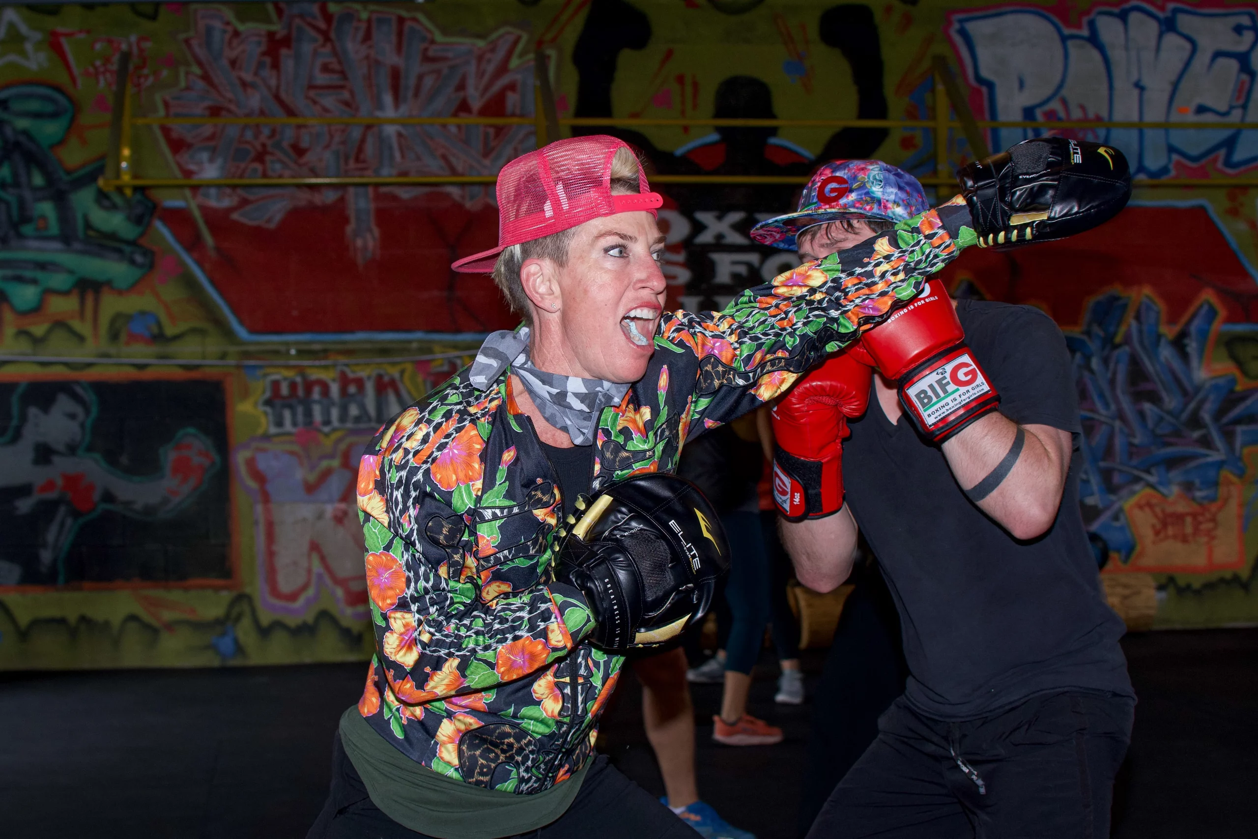 Eliza James throws a practice punch in a bright colored jacket and a hot pink hat.