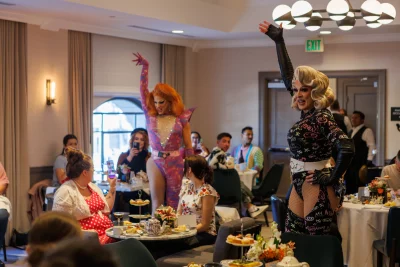 Erin Judgement and Scarlett Kiss wear pink and black jumpsuits, respectively, while striking a pose.