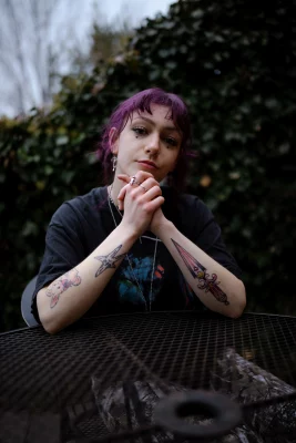 Croft clasps her hands together to show off her tattoos. 