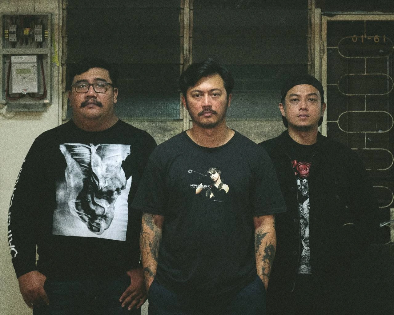 The members of Wormrot stand outside.