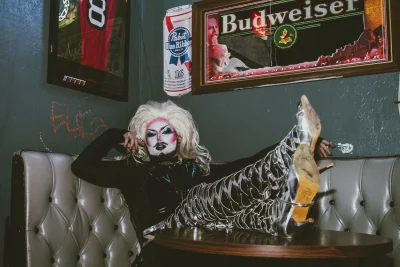 Lorem Ipsum sits at a silver booth with her legs on the table.