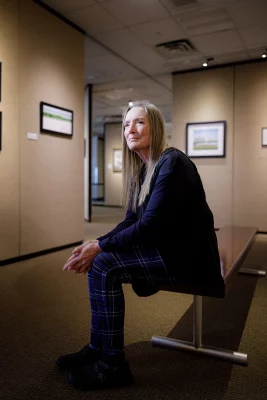 Linda Dalton sits in a gallery. 