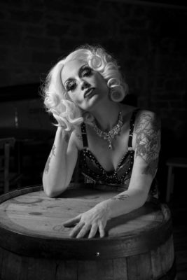 Kolumbia Monroe leans on a barrel, plumping her bombshell blonde hair.