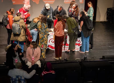 Attendees gather around Barber's table to look at his work. Photo: Derek Brad