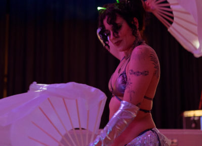 Cheree Salter dances with wavy fans in between performances. Photo: Emily Sorensen.