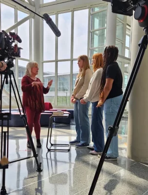 Ellen Hopkins is interviewed with camera and boom microphone.
