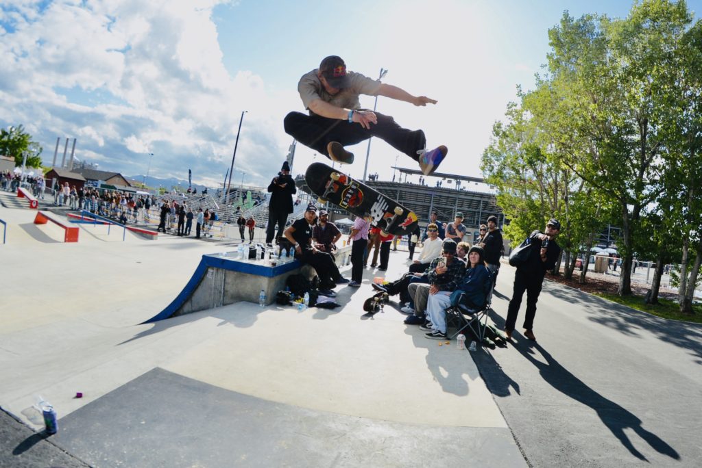 Man does trick through the air on a skateboard.