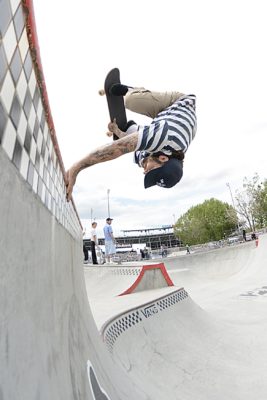 Man on skateboard doing a handplant on a halfpipe